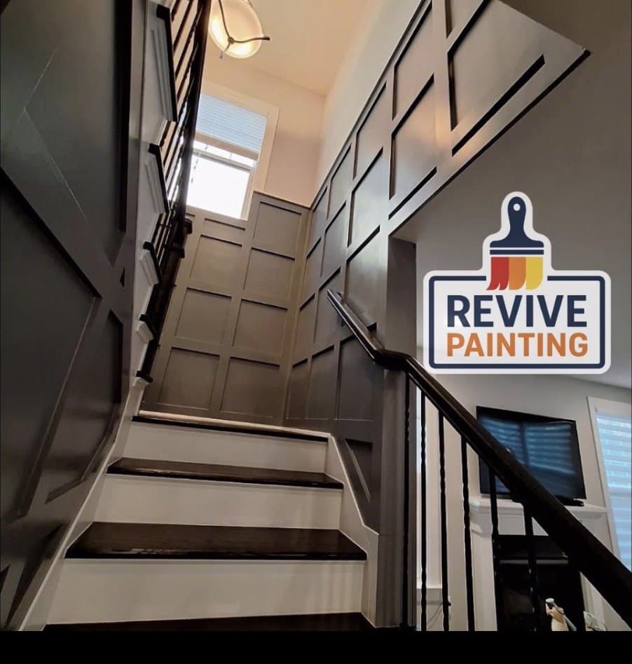 A staircase with a black board-and-batten accent wall and white risers
